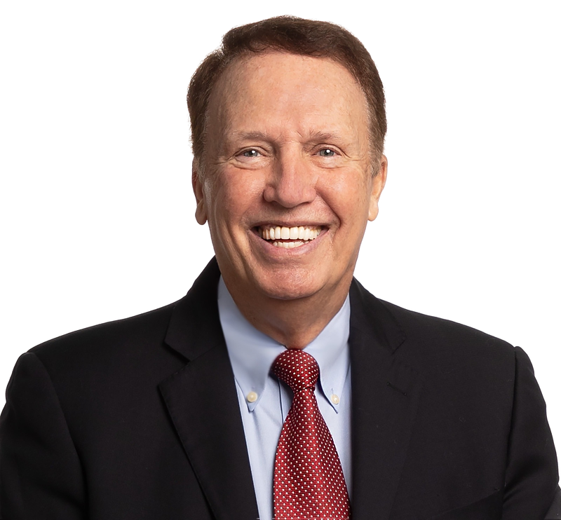 Dr. Robert Rohm, smiling, in a dark suit and red tie